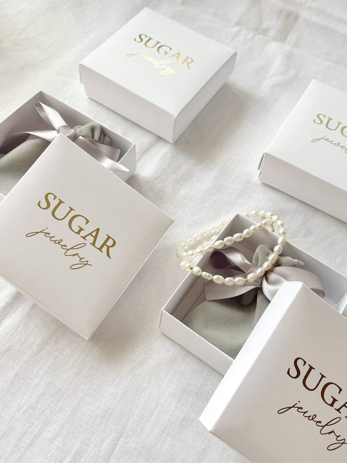 Фото №1 к отзыву покупателя Sugar Jewelry о товаре Коробочка с золотым лого 8*8*3 см белая  упаковка коробка и еще 1 товар