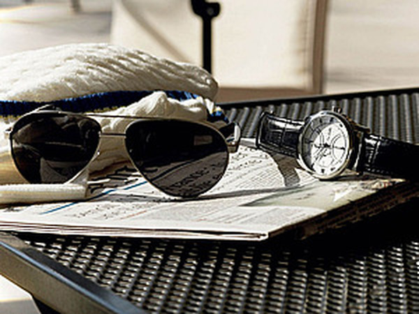 стильные аксессуары на столе: часы, сумка, очки